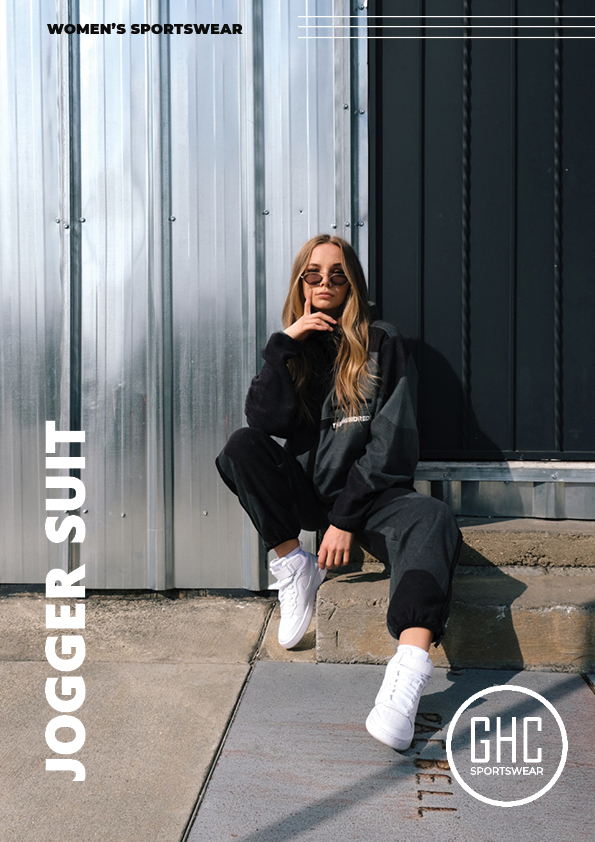 Woman wearing a stylish custom women's jogger suit, sitting casually against a metallic background, exuding confidence and comfort.