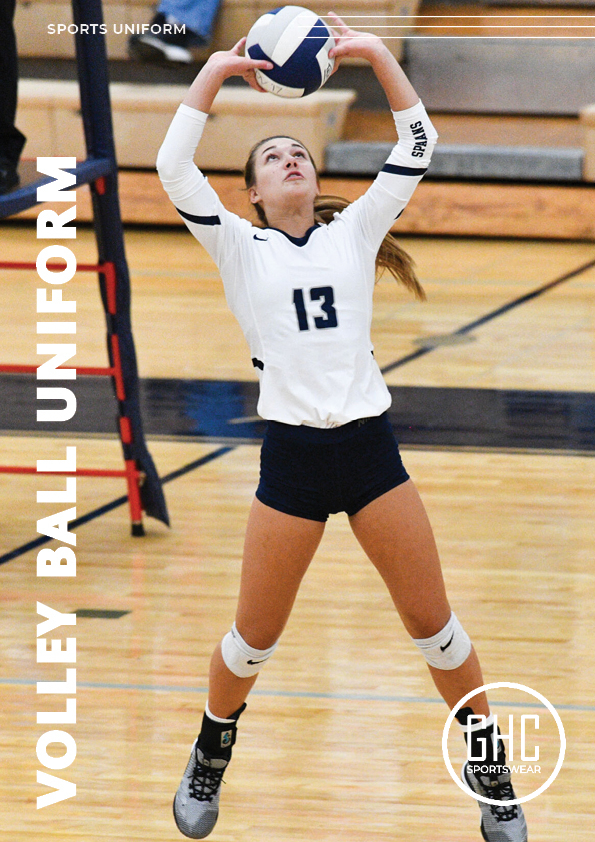 A female volleyball player wearing a custom uniform with the number 13, preparing to set the ball during an indoor game. The uniform features a white long-sleeve top, navy shorts, and knee pads, showcasing GHC Sportswear's customization options including color, logo, and player number.