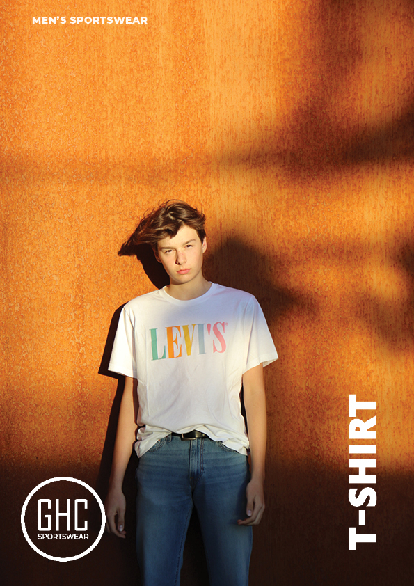 Model wearing a white Levi's t-shirt from GHC Sportswear's Custom Men's T-Shirt collection, standing against a rustic orange background.