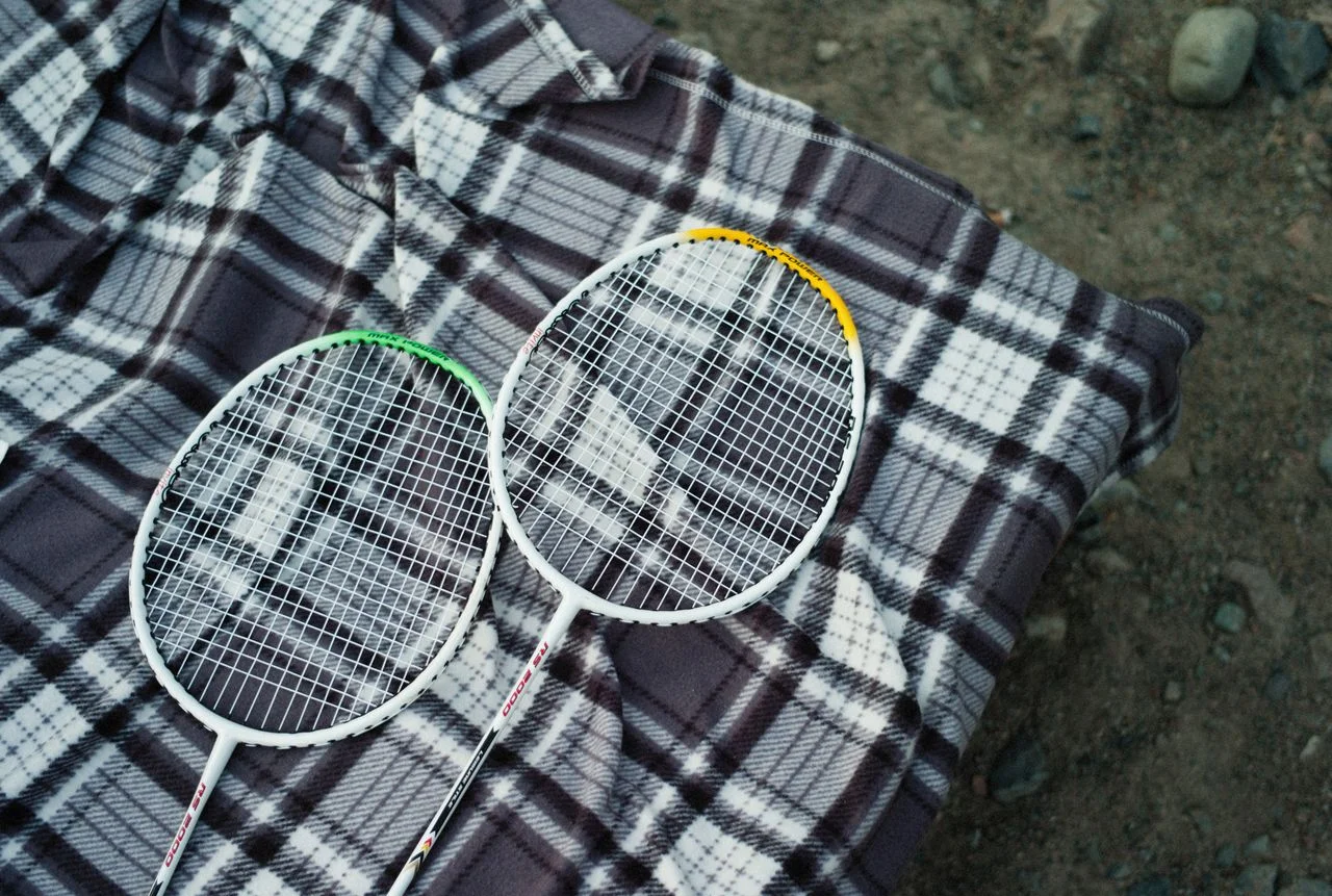 Materials revolutionizing badminton apparel including polyester, recycled polyester, mesh, spandex, nylon, and sustainable badminton uniform fabrics.
