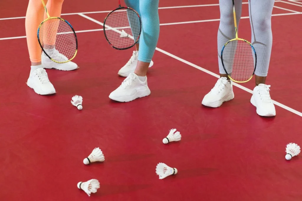 proper footwear in badminton shoes, grip, support, and court safety 2 Proper footwear in badminton with non-marking badminton shoes, court grip, cushioning, and custom badminton apparel.