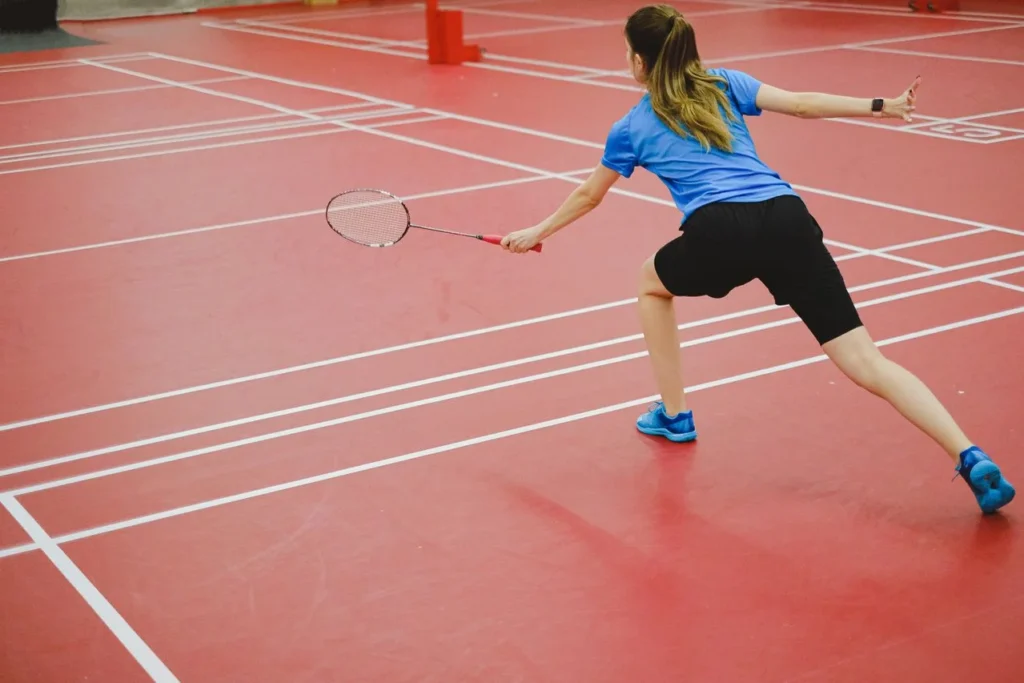 top 10 badminton drills to improve your game 2 Badminton drills on an indoor court with players practicing footwork, multi-shuttle training, net kills, serve accuracy, and custom badminton apparel.