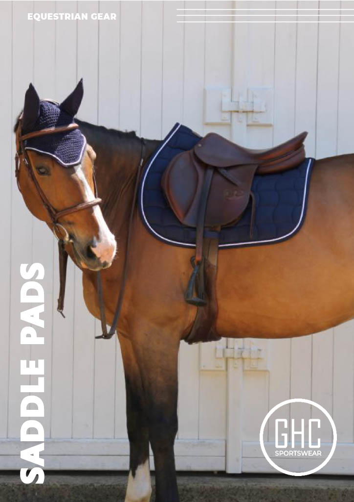 A horse fitted with a navy saddle pad and matching ear bonnet by GHC Sportswear®, representing high-quality OEM equestrian gear manufacturing and stylish riding essentials.