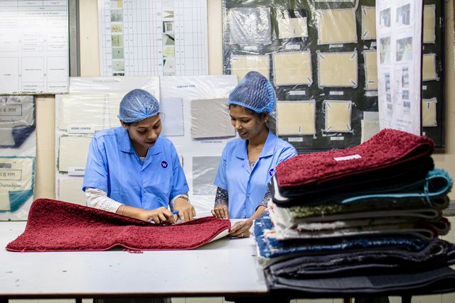 home 129 private label clothing manufacturer workers inspecting fabric quality in textile factory