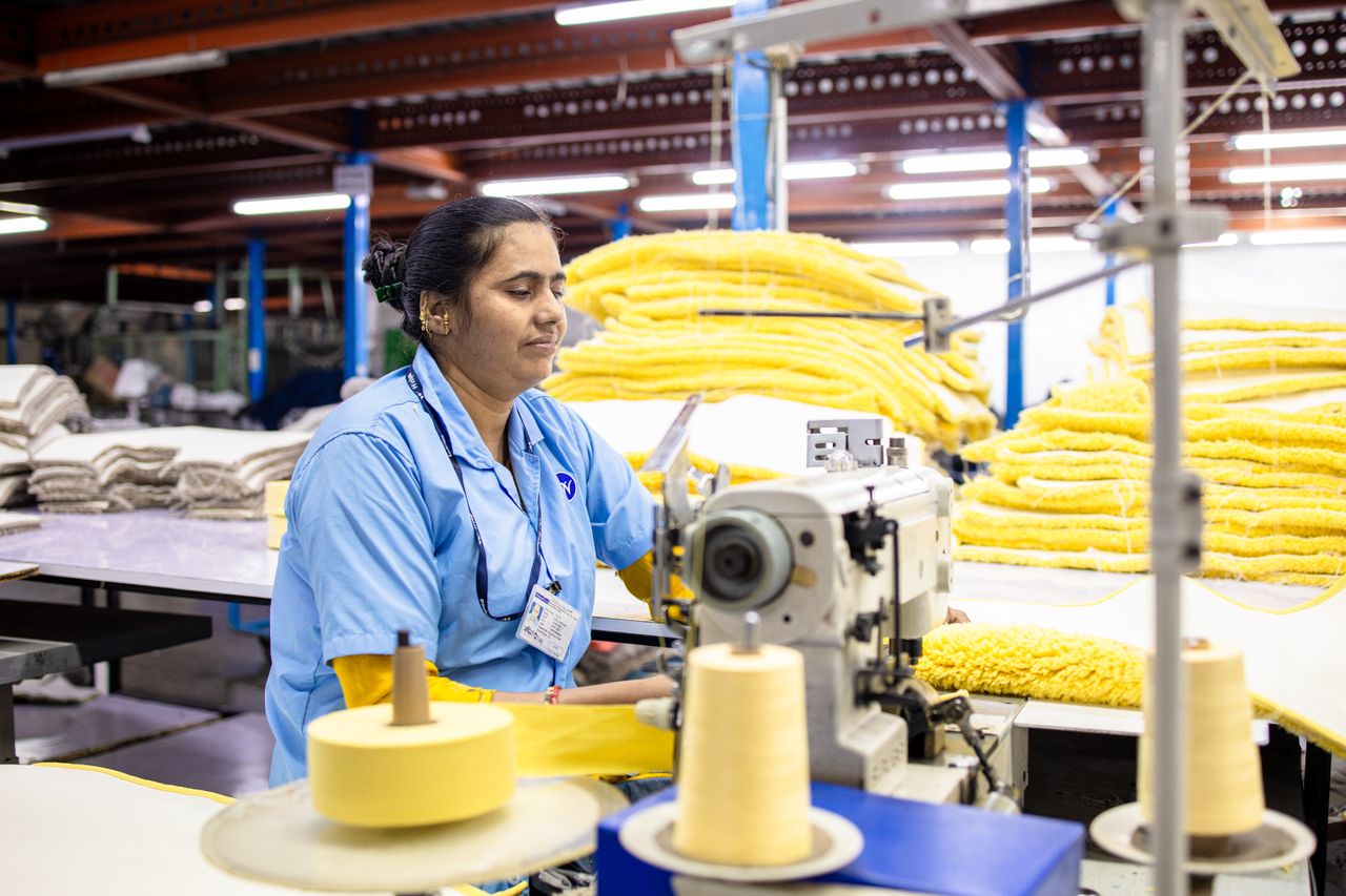 garment factory worker sewing clothing during the bulk clothing production process