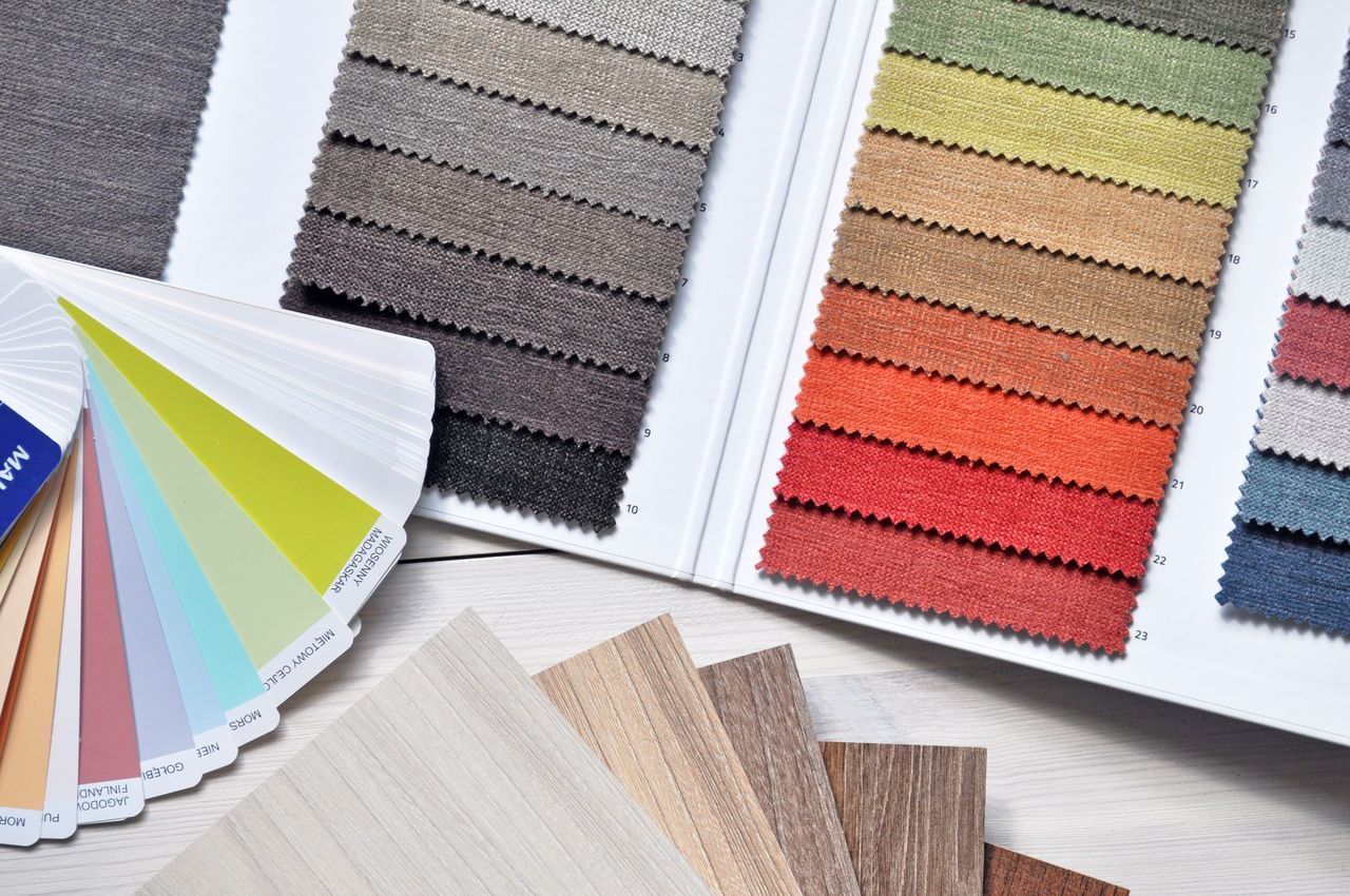 Garment technician comparing labeled fabric swatches during fabric sourcing for a private label clothing collection.